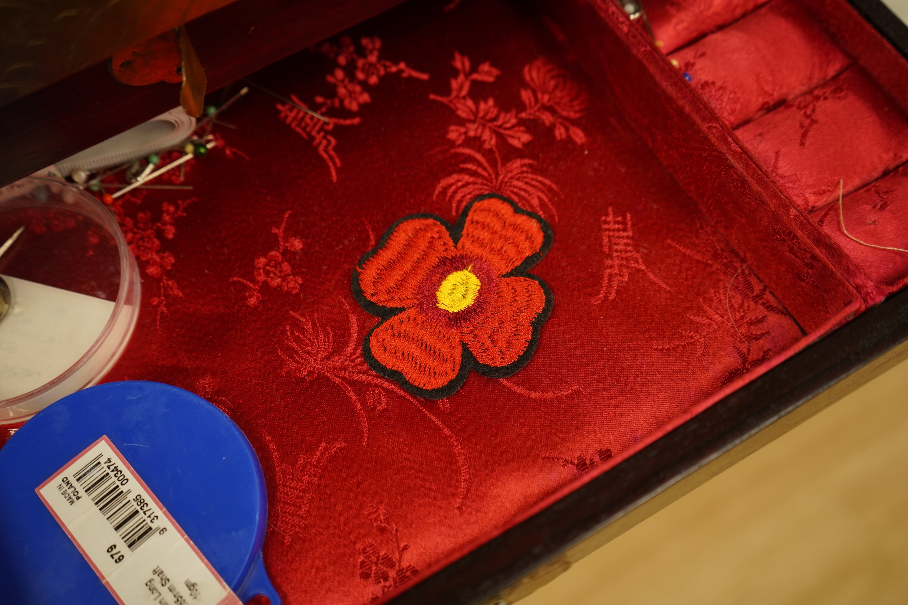 A Chinese brass bound rosewood jewellery box with twin handles, the interior with sewing accessories and threads, 35cm wide